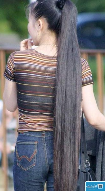 صورة لفتاة تعقد شعرها الأسود